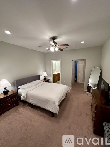 A bedroom with a bed, dresser, and mirror.