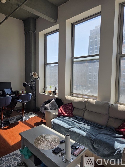 A living room with a couch, a coffee table, and a window.