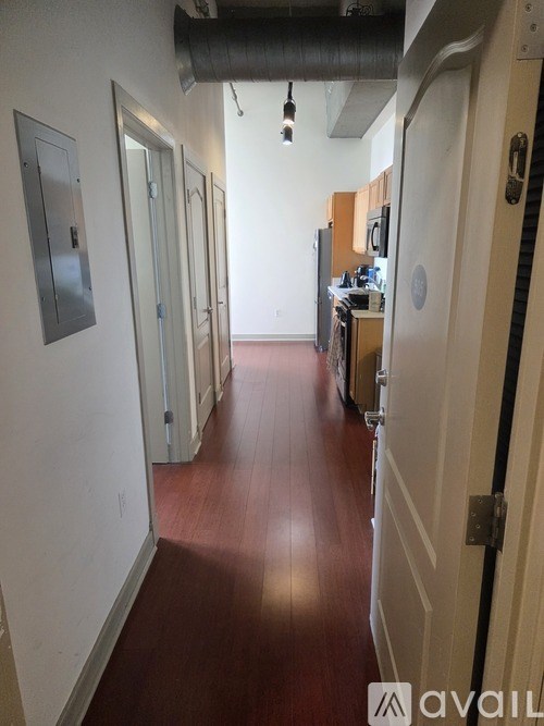A long hallway with doors on both sides and a white wall on the left.