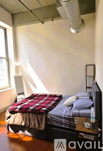 A bedroom with a bed, pillows, and a blanket.