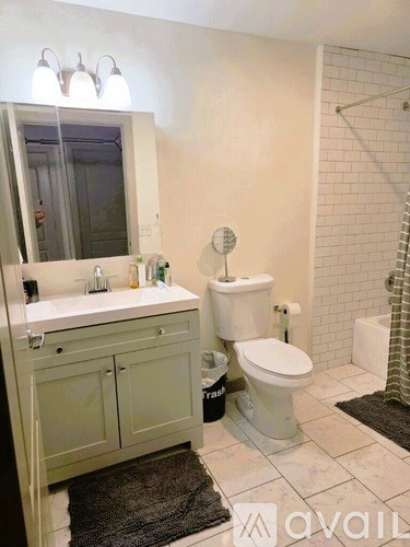 A bathroom with a toilet, sink, and mirror.