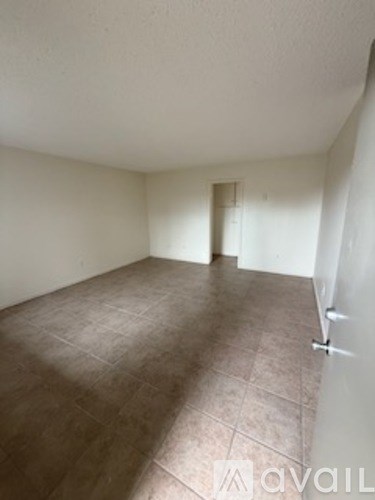 A room with a carpeted floor and a door in the background.