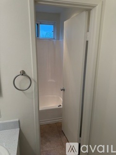 A bathroom with a toilet, tub, and window.