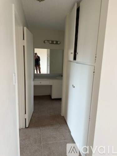 A man is standing in a hallway with a white door on the right.