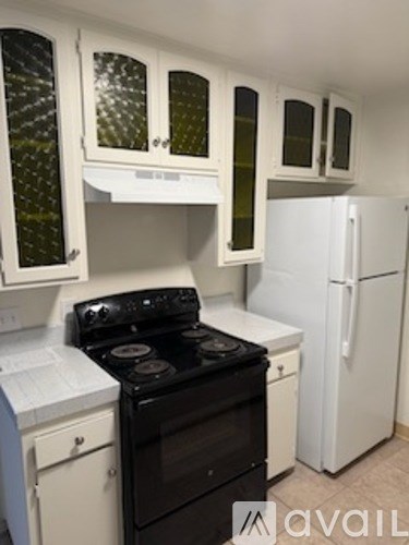 A kitchen with black and white appliances and cabinets.