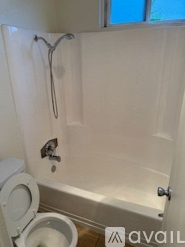 A white bathroom with a toilet and a bathtub.