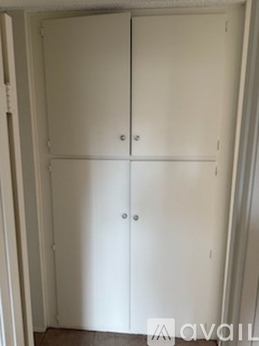 A white double wardrobe with two doors and two handles.