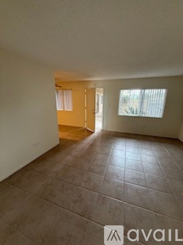 A room with a tiled floor and a window with blinds.