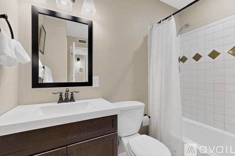 A bathroom with a white sink and a white toilet.
