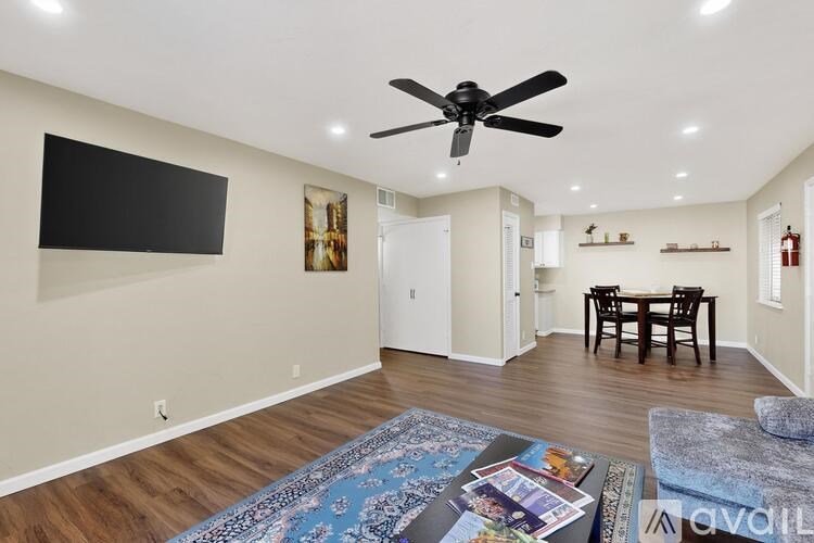 A living room with a ceiling fan and a dining table.