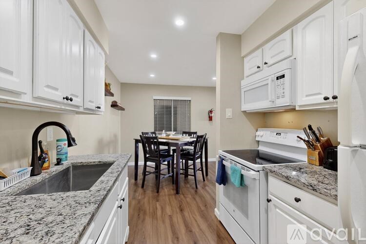 A kitchen with white cabinets and a granite countertop.