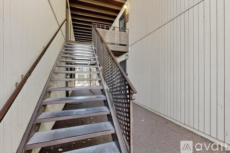 A staircase with a metal railing and wooden steps.