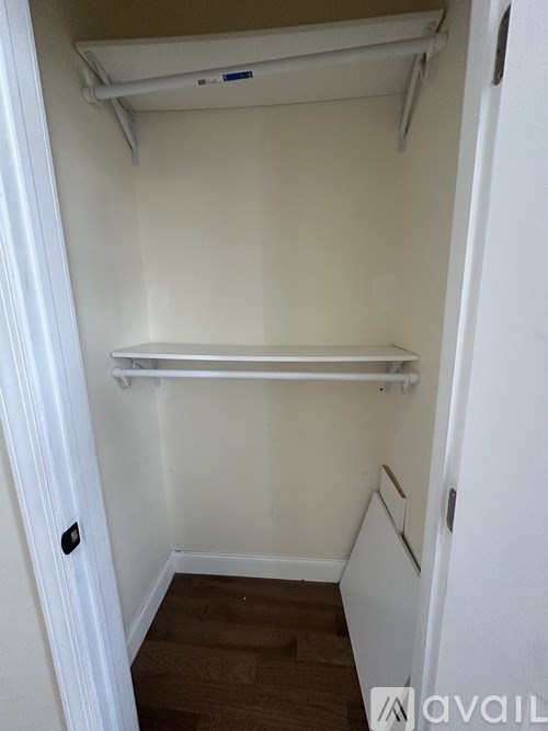 A small, empty room with a shelf and a door.