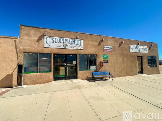 CJ's Coin Wash II storefront with a bench in front.