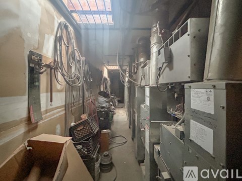 A cluttered industrial space with metal equipment and a skylight.