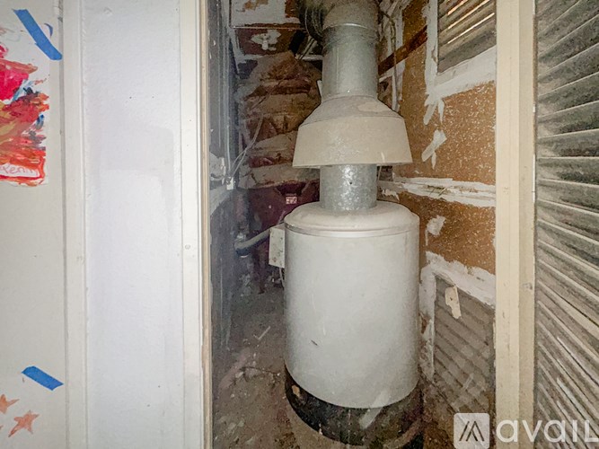 A white cylindrical object with a grey top is in the center of a doorway.