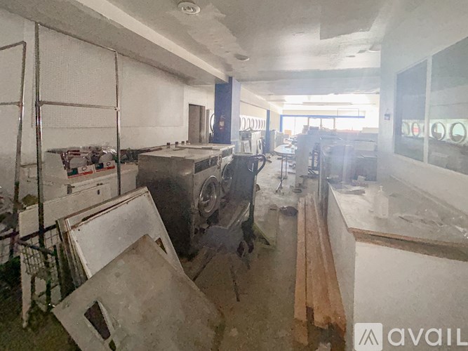 A room with a lot of construction materials and a car in it.