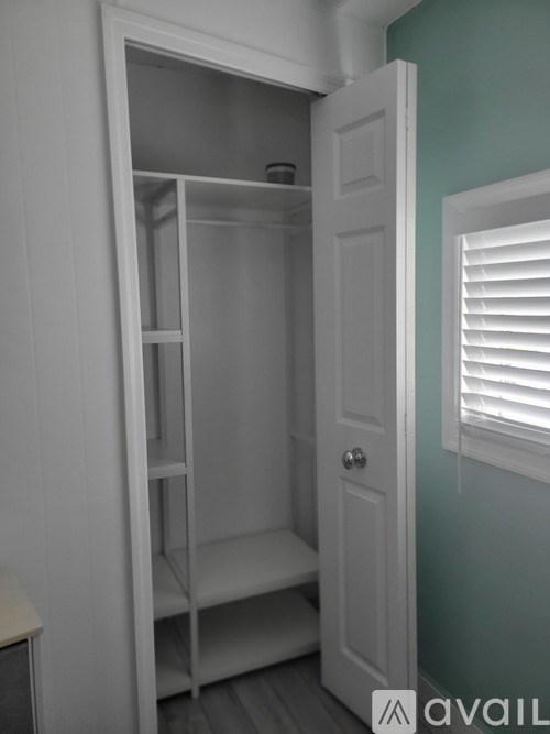 A white closet with shelves and a door.
