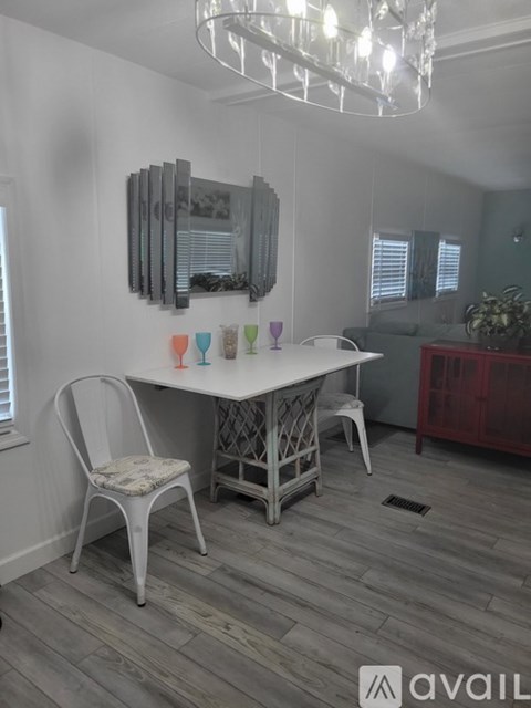 A dining room with a white table and chairs.