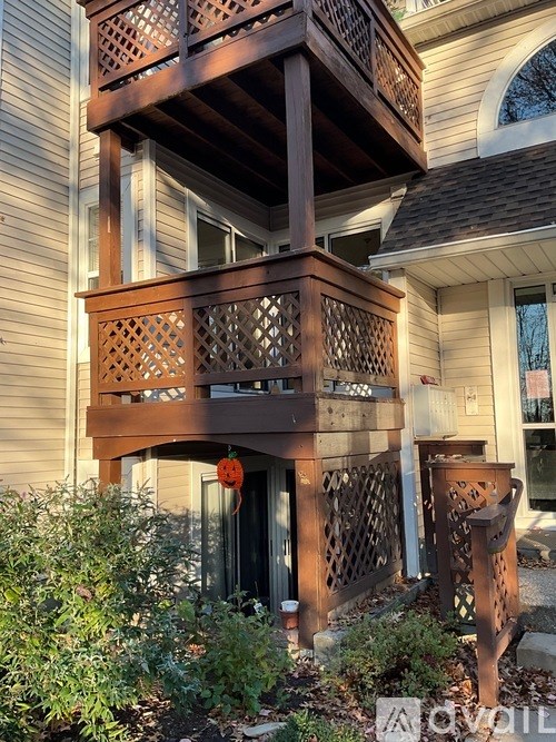 A wooden balcony with lattice work and a door with a glass window.