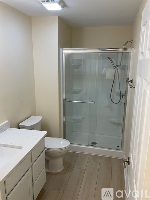 A bathroom with a toilet, sink, and shower.