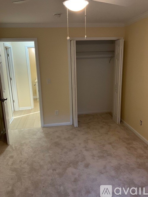 A room with a carpeted floor and a hanging light fixture.