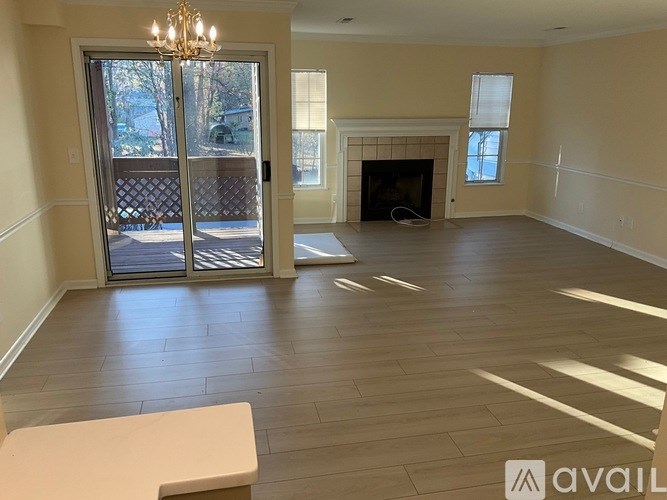 A large, empty room with a fireplace and a chandelier.