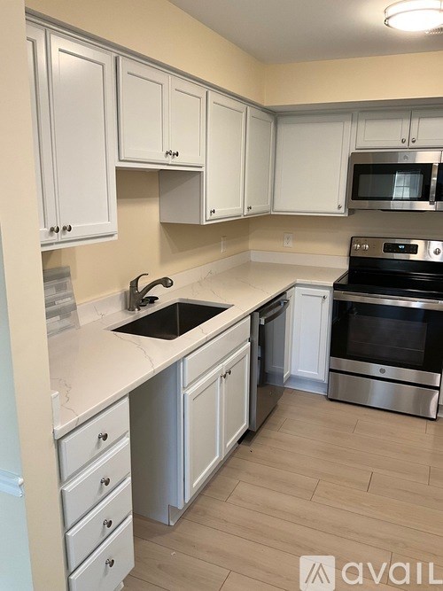 A kitchen with white cabinets and a stainless steel oven.