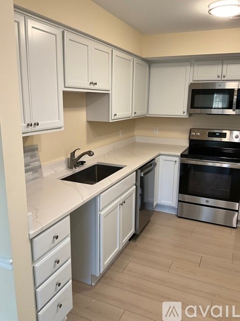 A kitchen with white cabinets and a stainless steel oven.