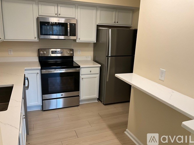A kitchen with a stove, refrigerator, and microwave.