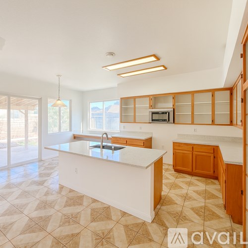 A kitchen with a white counter top and wooden cabinets.