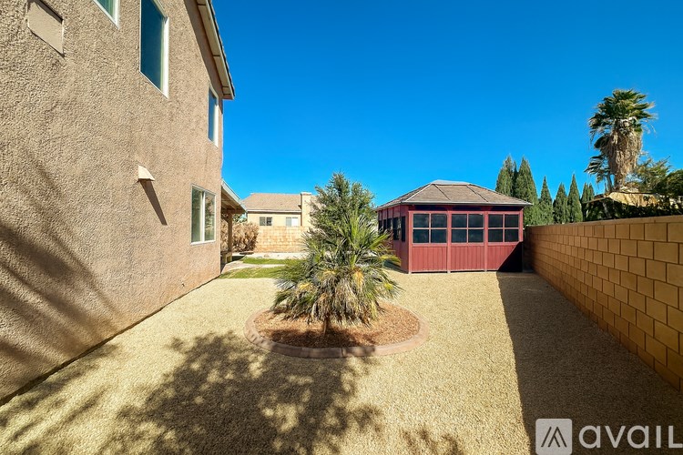 A house with a red building and a palm tree in the front yard.