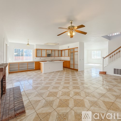 A spacious living room with a fan and tiled flooring.