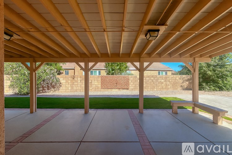 A covered patio area with a bench and pillars.