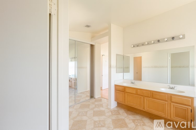 A bathroom with a vanity and a large mirror.