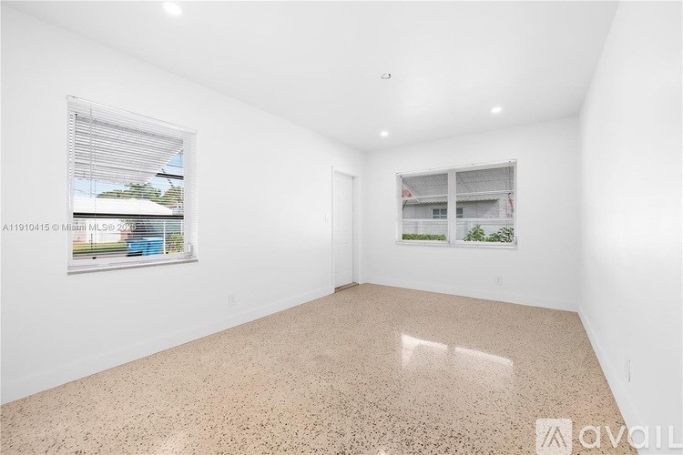 A room with a large window and a view of a building outside.