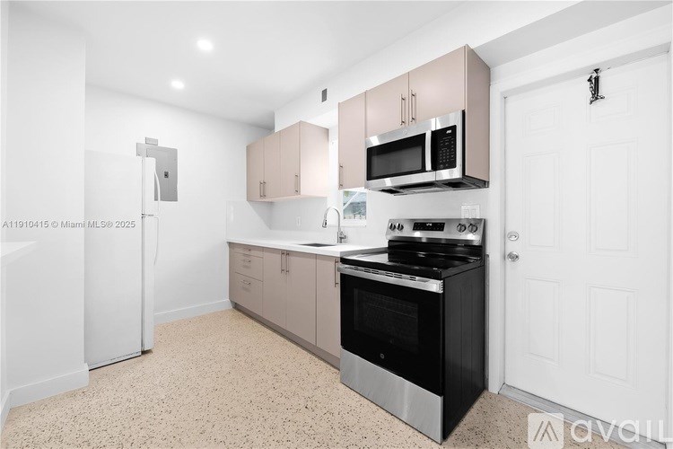 A kitchen with a black stove top oven and a white refrigerator.