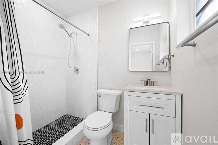 A bathroom with a toilet, sink, and shower.
