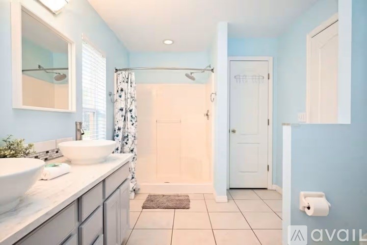 A bathroom with a white sink and a shower with a curtain.