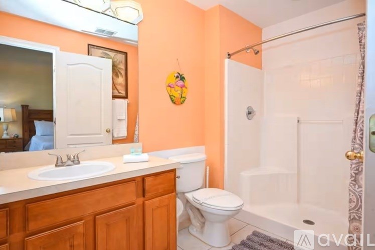 A bathroom with orange walls has a white toilet and sink.
