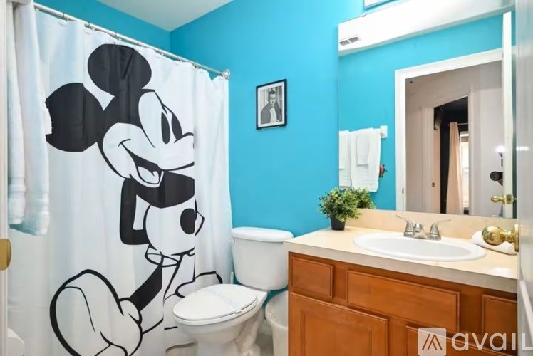 A bathroom with a Mickey Mouse shower curtain.