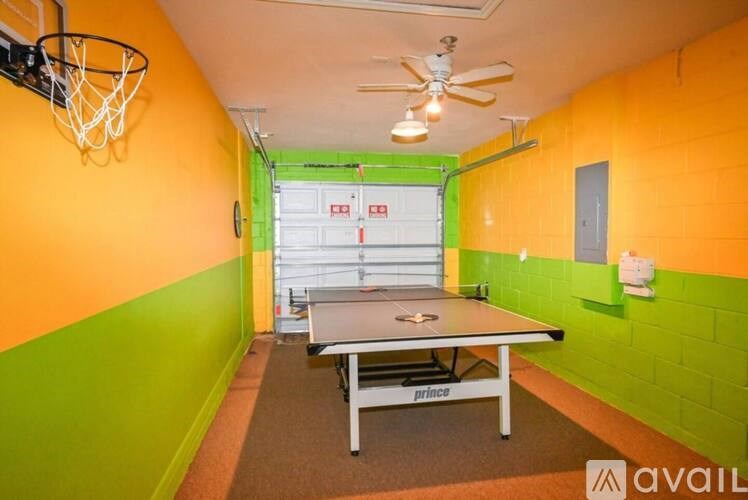 A basketball hoop is mounted on a wall with a basketball court in the middle of the room.