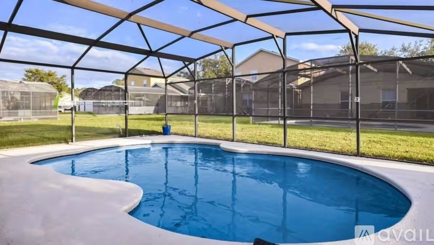 A residential pool under a black metal fence with a blue water body.