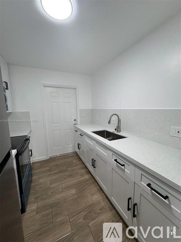 A kitchen with a sink and a refrigerator.