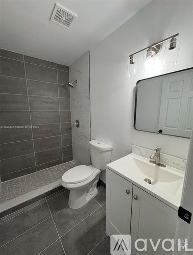 A bathroom with a toilet, sink, and mirror.
