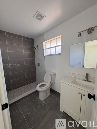 A bathroom with a toilet, sink, and a window.