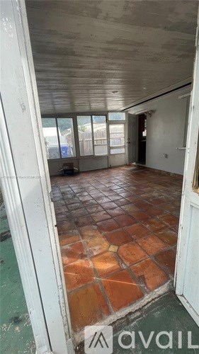 A room with a tiled floor and a doorway leading to another room.