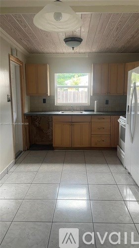 A kitchen with wooden cabinets and a white refrigerator.