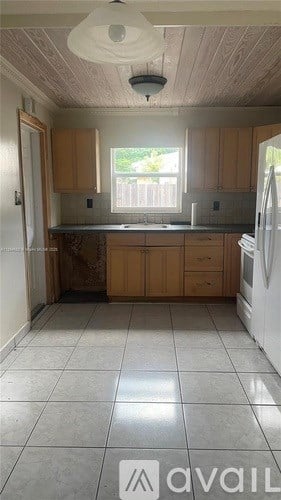 A kitchen with wooden cabinets and a white refrigerator.