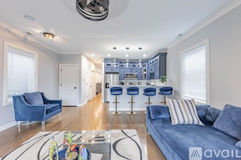 A living room with a blue couch and a bar area in the background.